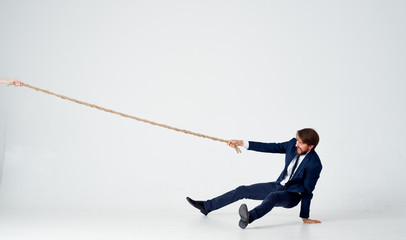 strong man in suit pulls the rope on an isolated background