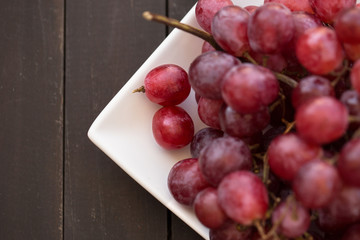 ahşap zeminde taze kırmızı üzümler