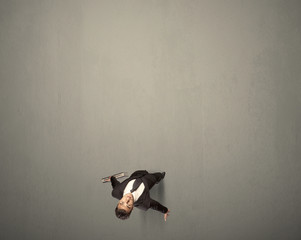 Young businessman contemplating a decision standing on a grey surface