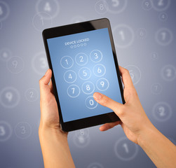 Female fingers touching tablet with locked device requiring passcode