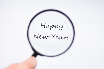 happy new year through magnifying glass on white background