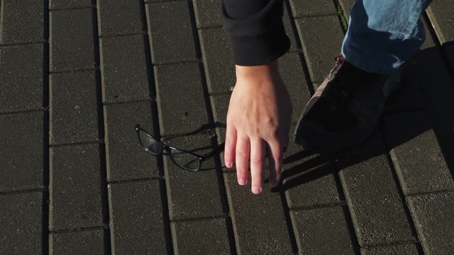 Man's hand finds dropped glasses
