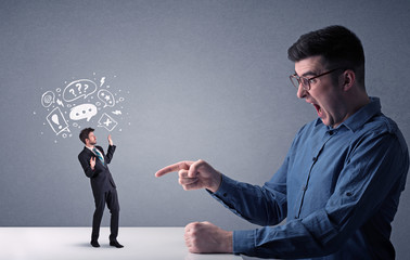 Young professional businessman being angry with an other miniature businessman who has drawn speech and thought bubbles above his head