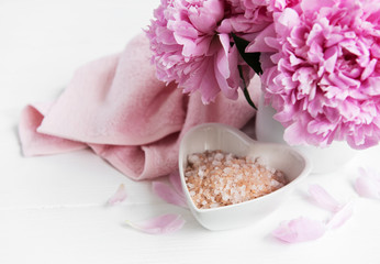 Bowl with sea salt,  soft towels and peony flowers