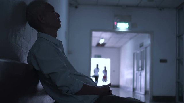 Senior Asian senior man sad worry and scare alone in hospital hallway