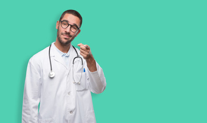 Confident young doctor pointing at you