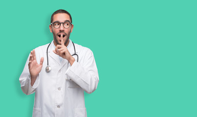 Naughty young doctor doing a gesture of silence
