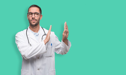 Young doctor doing a gesture of stop with his hands