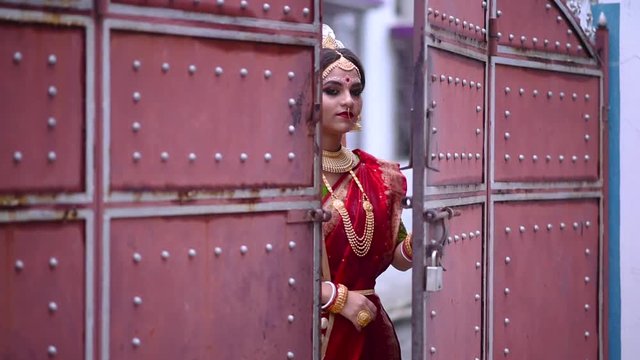 Smiling Indian Bengali Bride comes inside from outside a big gate