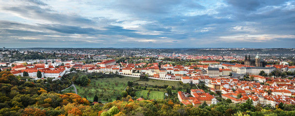 Bright and beautiful panoramic view on Saints Vitus Cathedral, Prague Castle, Old town and city center with old red roofs and dramatic sky, Prague, Czech Republic