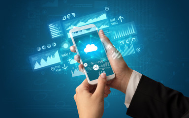 Female hand using smartphone with financial tracking concept illustrated by graphs and symbols