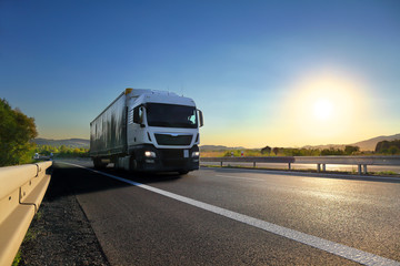 Fototapeta na wymiar Truck transport on the road at sunset 