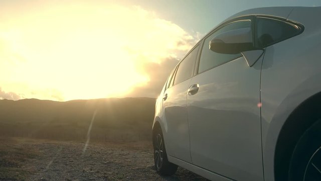 Time lapse of sunrise clouds reflecting on the side of a car. Automobile traveling