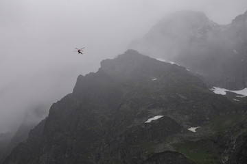 rescue helicopter in the mountains, heavy fog, Tatra