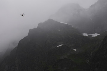 rescue helicopter in the mountains, heavy fog, Tatra