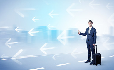 Young businessman hitchhiking near the city with arrows around concept