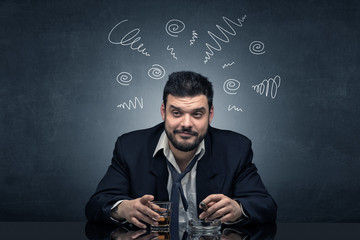 Young drunk man at his office with doodles around
