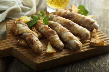 Grilled sausages wrapped with bacon