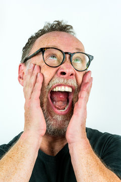 Close up portrait with white background of a adult male with grizzled beard and glasses shouting.