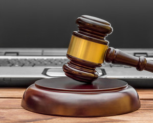 Judge's gavel with laptop on the table.