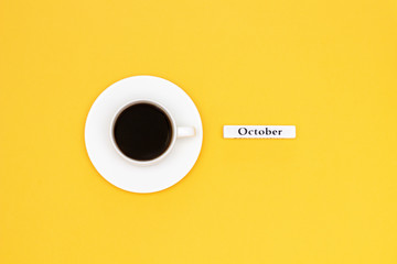 Cup of coffee and text October on yellow background