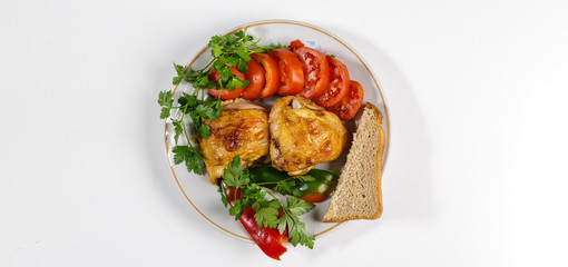 Fried chicken with vegetables on a round plate on a white background.