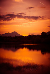 Fototapeta na wymiar A beautiful, colorful sunset over the mountains, lake and forest in purple tones. Abstract, bright landscape. Tatra mountains in Slovakia, Europe.
