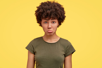 Photo of offended dark skinned girl being insulted by close person, dressed in casual militayr t...