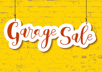 Calligraphy lettering of Garage sale in orange in paper cut style on yellow textured brick wall background for advertising, invitation, banner, poster, flyer, handbill
