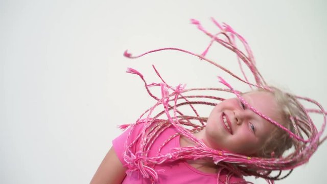 the beauty of slow motion - portrait of a beautiful light-skinned little girl of a non-standard modern appearance - with pink African plaits of zizi