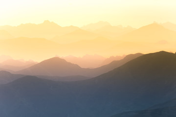 Fototapeta na wymiar Colorful, abstract double exposure of mountains in sunrise. Minimalist scenery with color gradients. Tatra mountains in Slovakia, Europe.