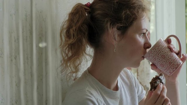 women sitting in a cafe restaurant eating cakes eclair drinking coffee and laughing