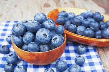 Blueberries in wooden bowls on wooden table