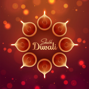 Top view of illuminated oil lamps on blurred glossy background for Shubh (Happy) Diwali celebration concept. Can be used as greeting card design.