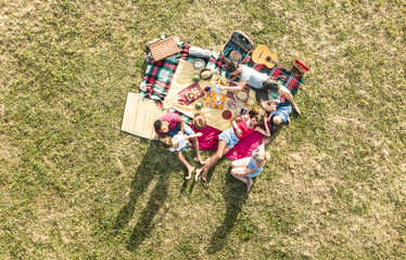 Aerial drone view of happy families having fun with kids at picnic barbecue party - Multiracial...