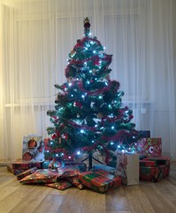 A Christmas tree under which there are gifts.