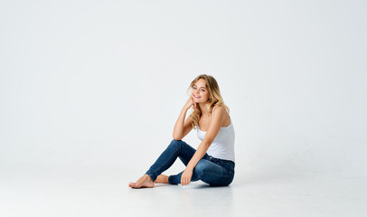 Fototapeta na wymiar woman sitting on the floor in a white t-shirt on an isolated background