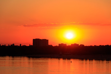 Fototapeta na wymiar Orange sunset over a river Dnieper in Kremenchug city, Ukraine