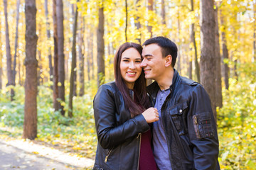 Fototapeta premium Love, relationship, family and people concept - smiling couple hugging in autumn park