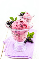 Ice cream with black currant in two glasses on light board