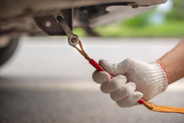 Hand holding yellow car towing strap with car, car towing, towing rope,copy space.