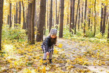 Fototapeta premium Child, nature and family concept - happy little girl laughing and playing in the autumn on the nature walk outdoors