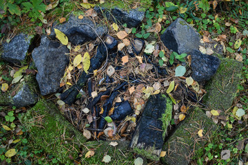 This is a grilling area in the middle of the forest which was last used in summer. Now, the leaves and weeds start to fill the ground.