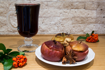 Hot mulled wine with low fat healthy dessert: baked apples with cinnamon and brown sugar, decorated...