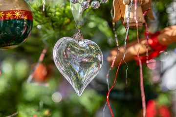 A heart shaped Christmas decoration hanging on a Christmas tree
