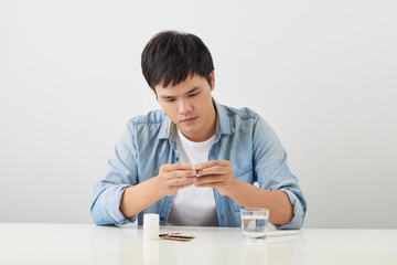 man taking pill out from blister pack at home
