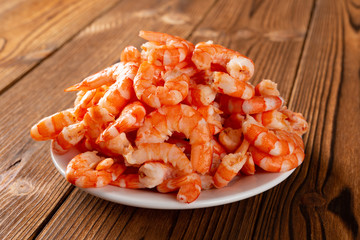 side view studio shot of peeled shrimps on a dish