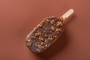 chocolate outer ice cream with peanuts on a brown background