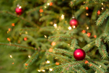 Decorated Christmas tree on blurred, sparkling and fairy background.Magically decorated Christmas Tree with red balls, on a blurred shiny, sparkling background. Happy new year card