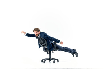 man in a suit riding a chair on an isolated background
